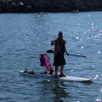 Guy dressed like uncle sam paddleboards on lake