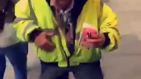 Safety vest man dances next to passed out girl being held up by friends