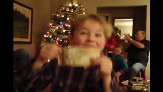 Boy dances with his christmas present and rips it in half