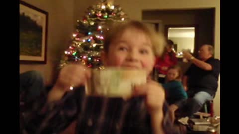 Boy dances with his christmas present and rips it in half