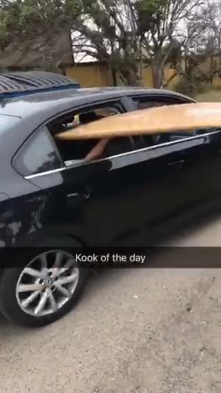 Wooden surfboard sticking out from car window