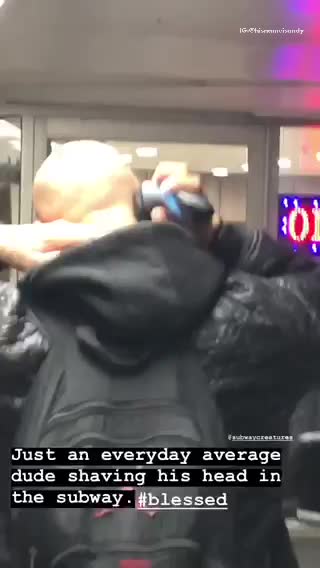 Man shaving head as he walks in subway