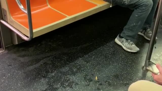 Man carving wooden figure on train