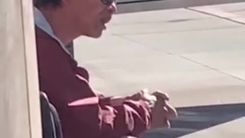 Guy flicks his tongue up and down waiting for bus stop