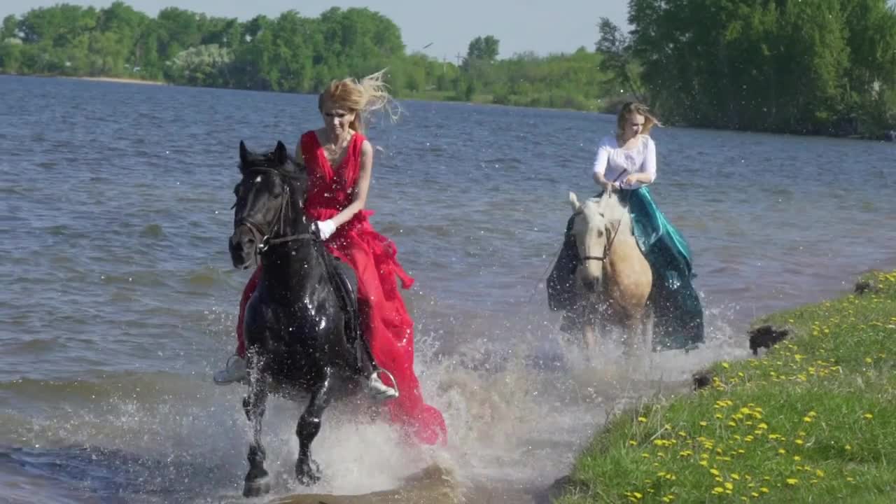 Horses riding on the beach at sunset