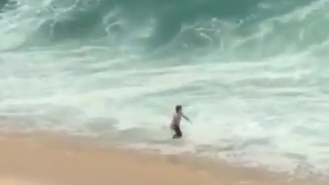 Guy walks into ocean slammed by wave