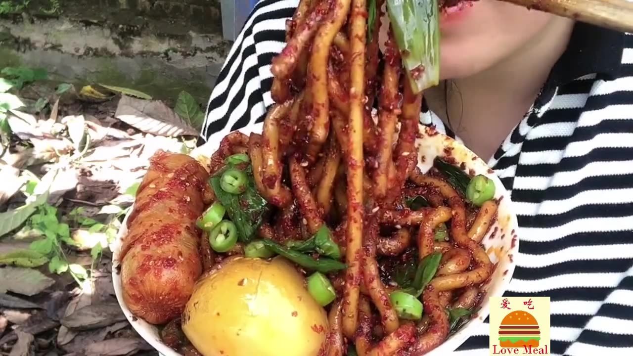 Big bowl of spicy rice noodles with grilled sausage and potatoes, stir-fried chicken