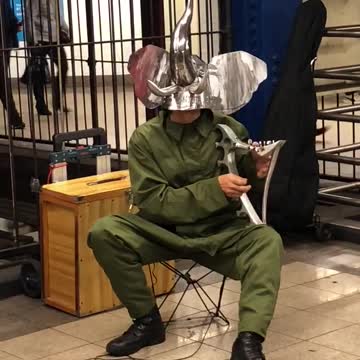 Metal elephant man plays metal harp in subway terminal