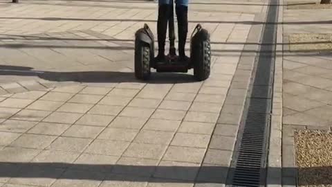 White coat girl rides segway down sidewalk and faceplants