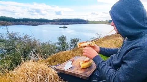 Crispy cheese pizza crust with a beautiful view of the lake. ASMR cooking