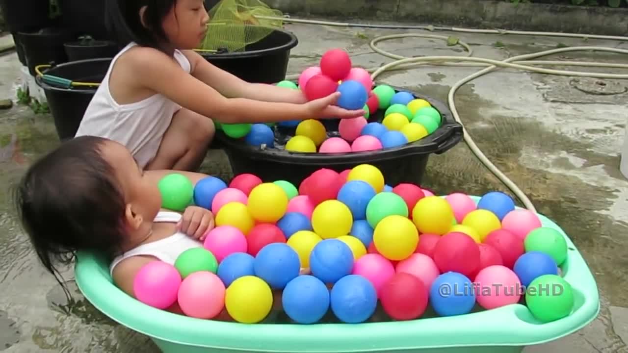Cute Little girl Playing Colorful Balls in Mini Pool