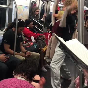 Two weird people acting out as dolls on subway floor break dancing singing