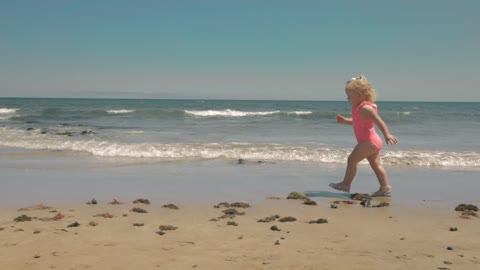 Toddler playing with a beach ball