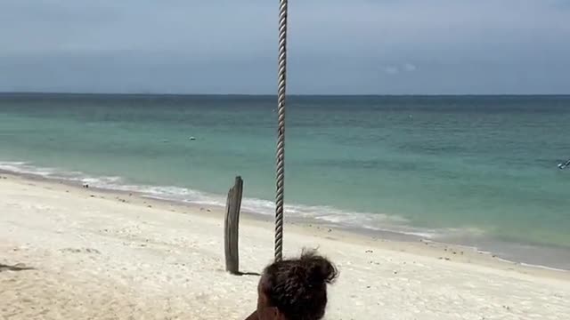 A Woman Swinging on the Beach