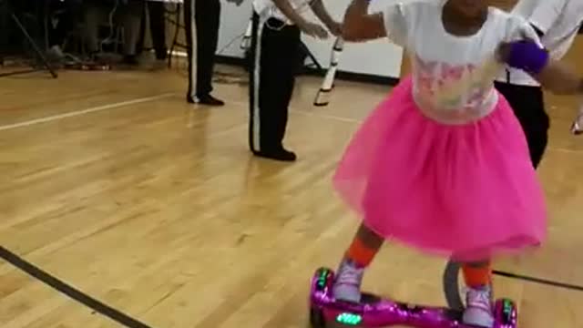 A Little girl making complicated moves on a hoverboard