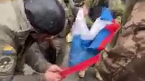 The Russian flag is being torn down and burned by Ukrainian troops