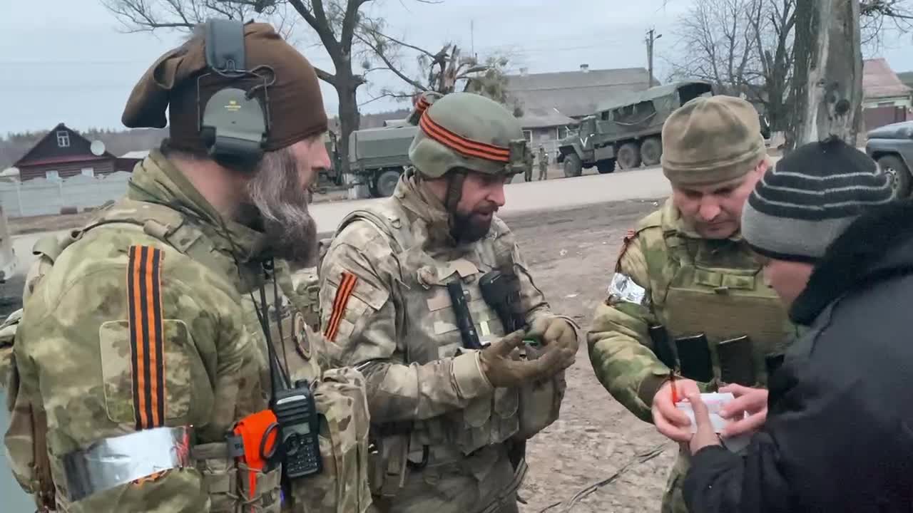 Officers of the Special Forces unit of the Russian Guard help a local resident
