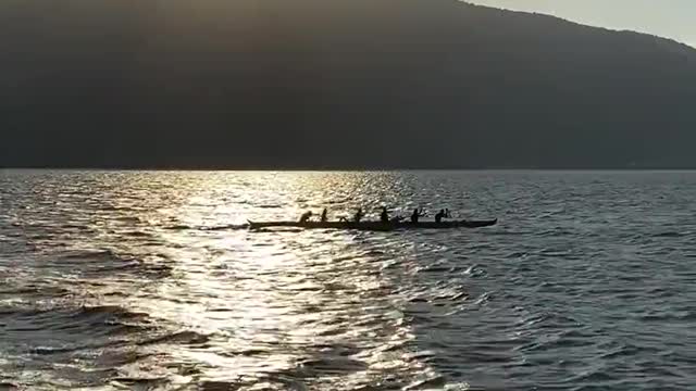 Silhouette of People in a Canoe in the Sea