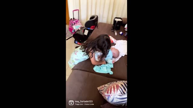 Big sister adorably changes newborn baby's diaper