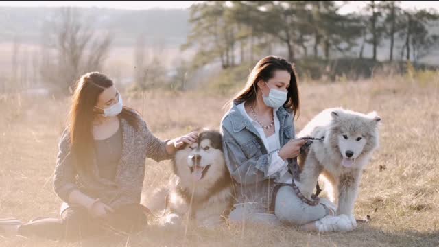 Women With Face Masks Petting Dogs