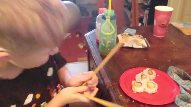 Henry eats sushi with chopsticks