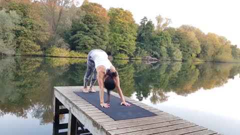 Woman Doing Stretching Exercises On Wooden Dock