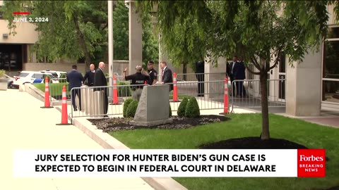 A Man Carries A Sign Reading 'Putin's Fingerprints Are On That Gun' Outside Hunter Biden Courthouse