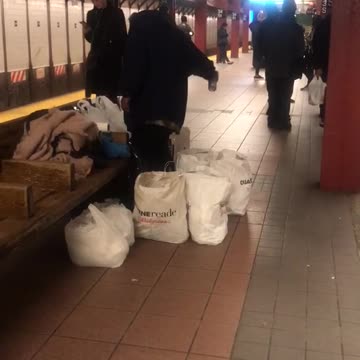 Homeless person spraying air freshener around hobo fort in subway