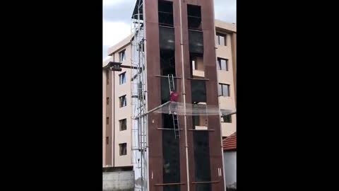 Skilled man from Bulgaria expertly uses a ladder to climb up tall building