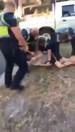 Australian Police kick handcuffed man in the chest.