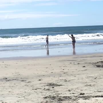 Woman doing tai chi stretches on beach