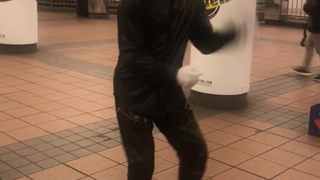 Guy with flashing grills dances in a subway