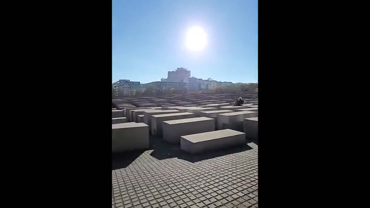 Woman sits on memorial and has a photoshoot at the Memorial to the Murdered Jews of Europe