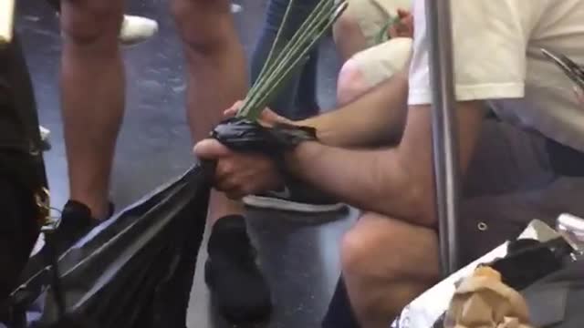 Man drinking from many green straws black bag