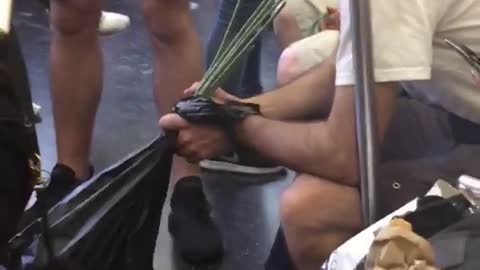 Man drinking from many green straws black bag