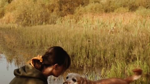 Young Woman Playing with Her Nice Pet Dog Outdoors