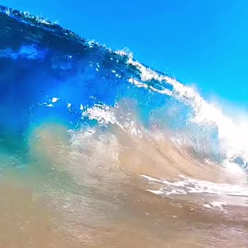 The inside of a beautiful, blue, breaking wave