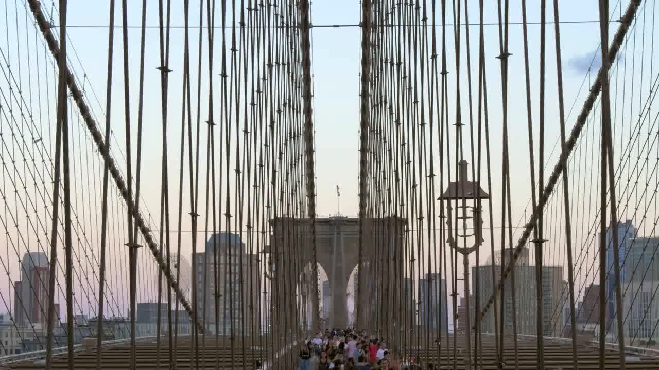 Panning Down to show Poeple Walking Over Brooklyn Bridge