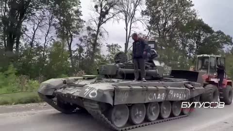 Ukrainian tractor drivers take out a captured Russian T-72B3 tank near Izyum.