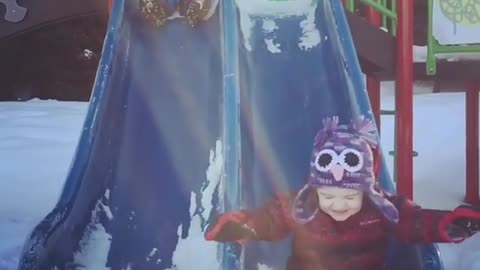 Snow two kids slide one faceplants