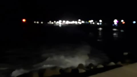 Rough and fast crashing waves on the breakwater at night
