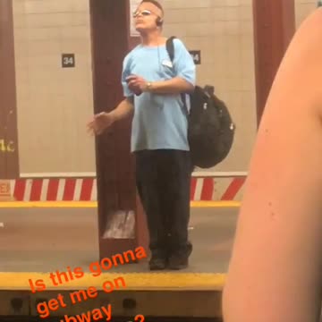 Man in blue shirt dancing on subway platform