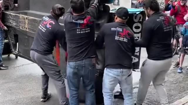 Many people work together to carry the racing car and get ready for the race.