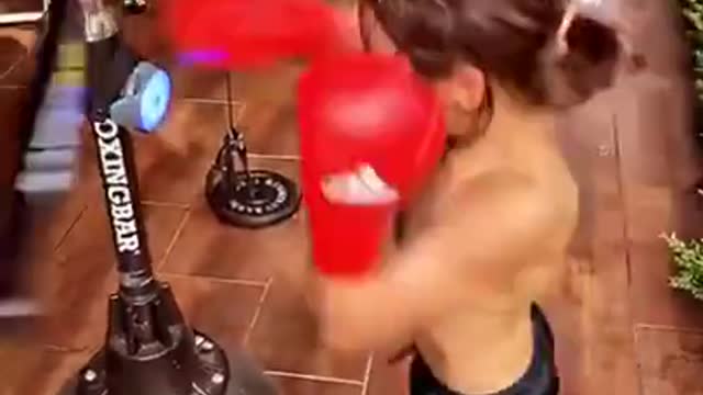 Little Kid Practices Boxing With Spinning Bar And Punching Ball