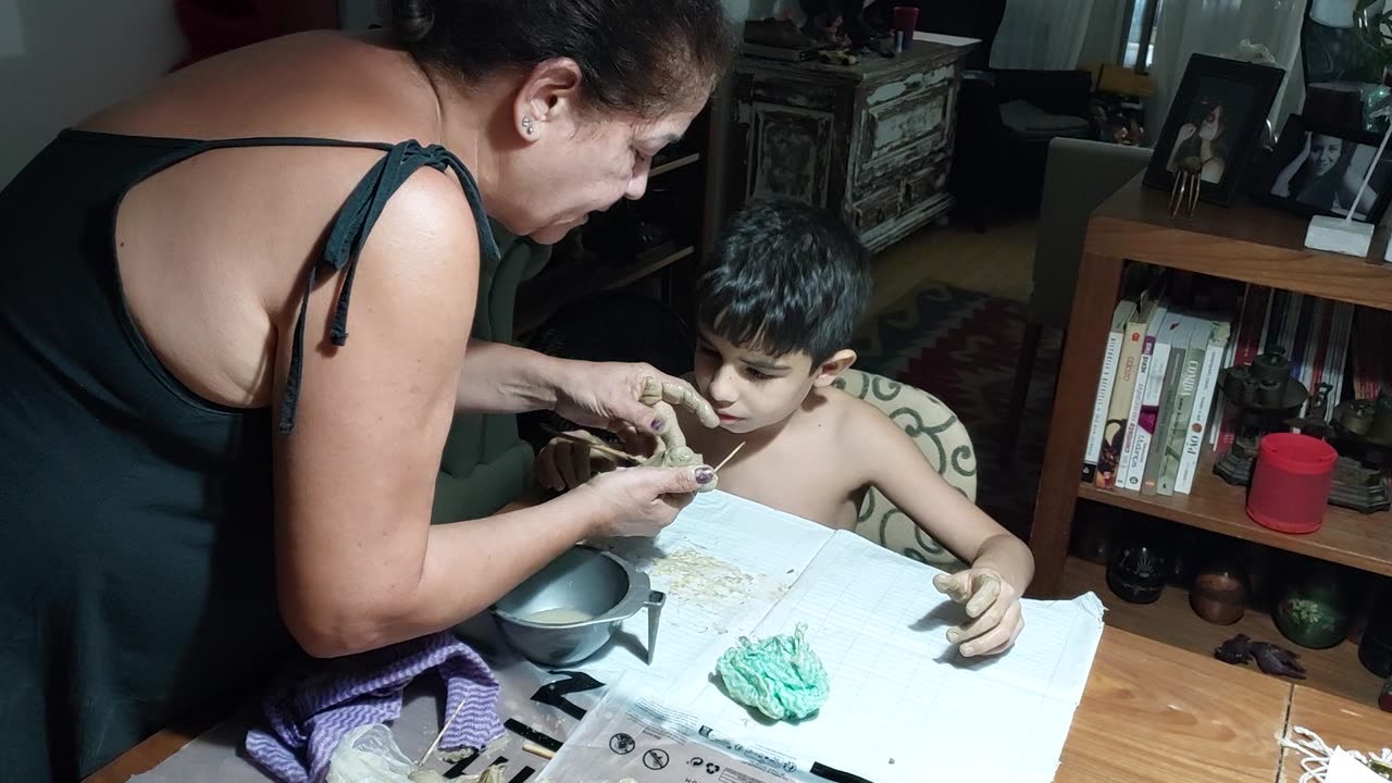Avó ensinando neto a fazer esculturas