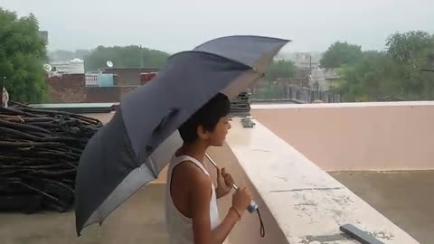 Little boy enjoying the rainy season.