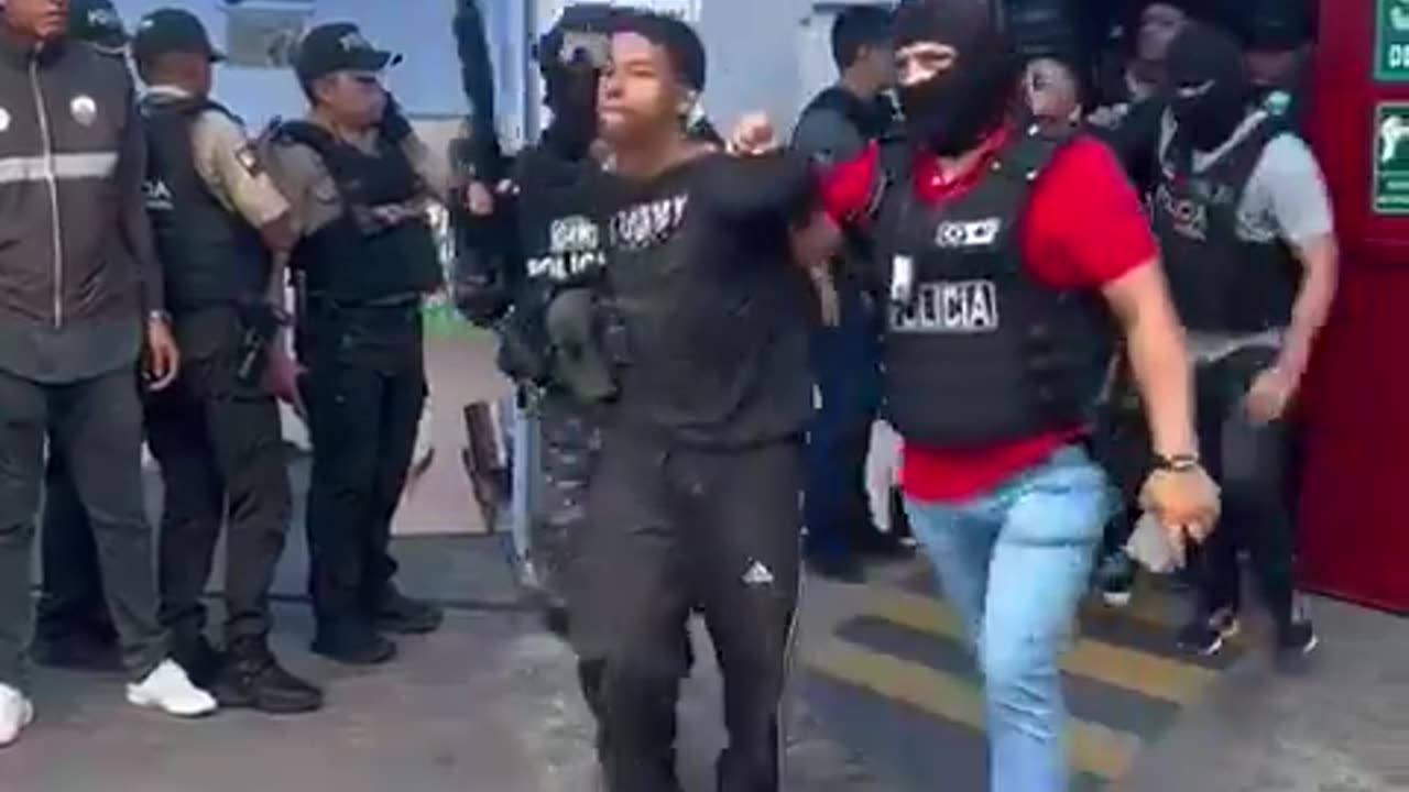 Footage of police escorting arrested cartel members out of the Ecuadorian Television studio.