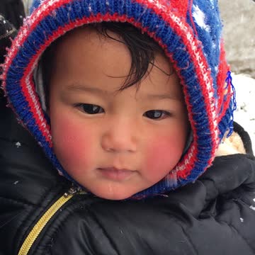Cute baby enjoying snowboarding