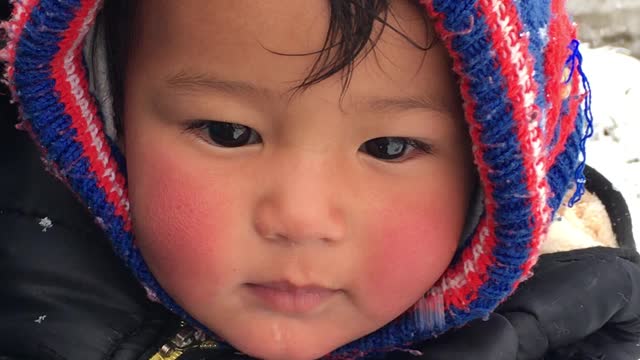 Cute baby enjoying snowboarding