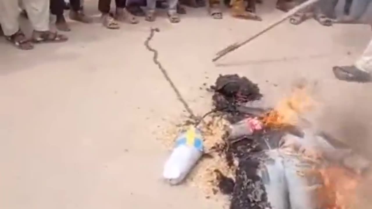 Muslims burn effigy of man with Swedish flag.